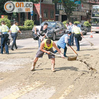 警員及工人在場清理馬路泥濘。