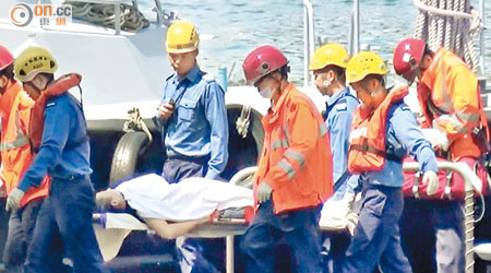 救援人員將蹈海女子抬至水警基地。（趙瑞麟攝）