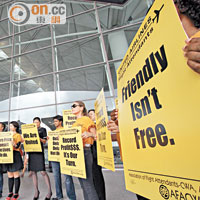 香港<br>聯合航空約卅名員工昨身穿橙衣，於香港機場一號客運大樓外高叫口號，要求合理待遇。(梁耀榮攝)