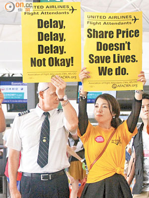 在港發起抗議行動的聯合航空員工，舉着標語無聲抗議。(梁耀榮攝)