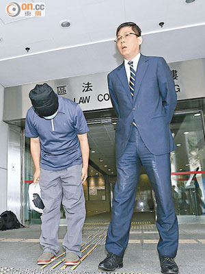 被告蘇錦璋（左）在律師（右）陪同下，在法院外三度鞠躬。
