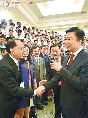 楊受成（左）赴京出席青年交流團活動，期間獲李源潮（右）親自接見及握手。（受訪者提供）