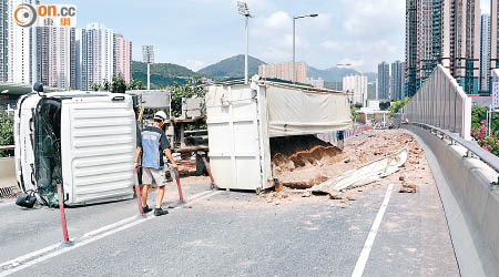 肇事泥頭車翻側，路面留有三十米「泥路」。（陳浩然攝）