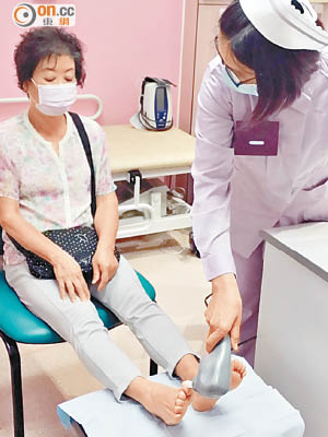 謝太（左）在觀塘社區健康中心接受「生物震感測量器」檢查。（黃卓然攝）