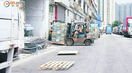 工人使用剷車，公然將馬路及行人路當作卸貨區。