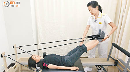 運用「核心床」器械，頭及腰背貼着床，靠核心肌肉及腳力拉動繩子，鍛煉核心肌肉。