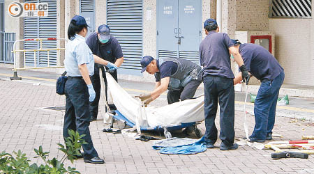 仵工將男經理遺體舁送殮房。（曾志恒攝）