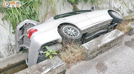 私家車跌落引水道翻側。（戴展邦攝）