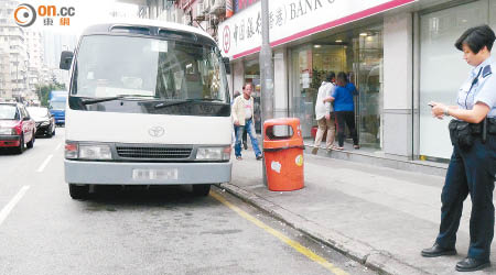 警員在校巴遭擲現場調查。（冼耀華攝）