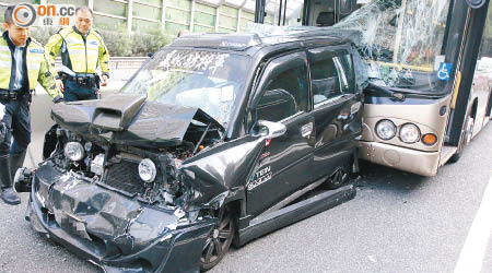 一輛日本K-Car被夾變「三文治」，車頭嚴重損毀。（左錦鴻攝）
