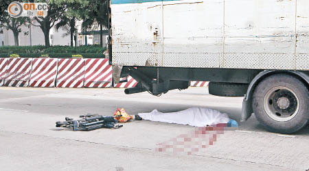 老婦伏屍車底，旁邊遺下輪椅。（張世洋攝）