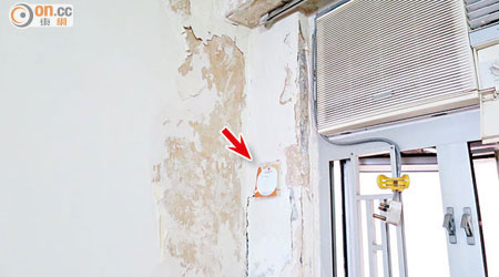 客廳牆壁上的插座（箭嘴示）亦因滲水而無法運作，令張太的生活嚴重受影響。