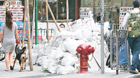 四、五十袋「聖誕老人」形成的小山丘，霸佔黃竹街半條行人路。（黃雄攝）