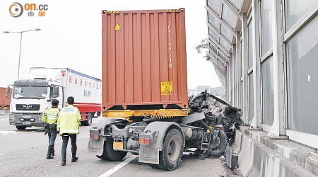 肇事貨櫃車猛撼石壆，車頭幾「拗甩」。（曾志恒攝）