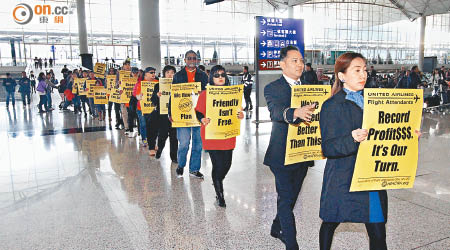 廿名聯合航空機艙服務員及香港空勤總工會代表昨早於本港機場客運大樓遊行，爭取統一勞工合約。（何天成攝）