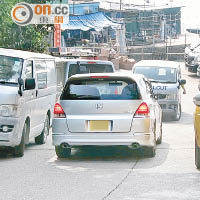 違泊車輛令道路大幅狹窄，致出現對頭車爭路的情況。