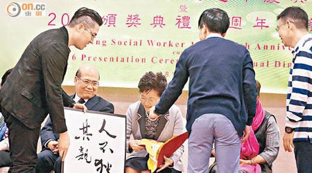 林鄭月娥出席頒獎活動時，有得獎社工向她展示標語抗議。（黃仲民攝）