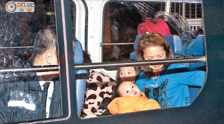 天寒地凍，一名女子與兩名小童上警車暫避。（麥少峰攝）