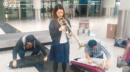 吳寶頤（中）隨樂團乘港龍航空由內地返港，發現其心愛長號損毀，心痛不已。（受訪者提供）