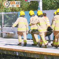 消防員將跳軌男子的遺體抬上月台。