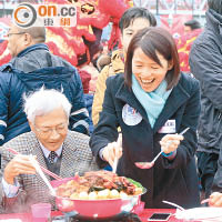 葉文娟（右）食盆菜時笑逐顏開，左為市建局主席蘇慶和。（溫國佳攝）