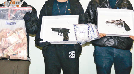 警方展示檢獲的現金及兩支仿製手槍。（莊杰成攝）