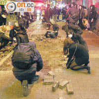 暴徒撬起地磚作為攻擊警方武器。