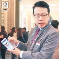 陳欽勉拎住手機與人分享保良局facebook專頁。