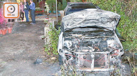 警員在縱火案現場調查，私家車焚毀。（文健雄攝）