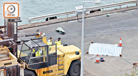 女工遭貨櫃起重機車輾斃，屍體用帆布蓋着。（李國健攝）