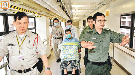 獨家圖片<BR>在醫護人員及懲教人員押送下，劉夢熊坐輪椅到另一大樓照Ｘ光檢查。（蔡高華攝）