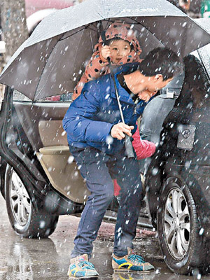 遼寧瀋陽率先降溫，市民要冒着雨夾雪出行。（中新社圖片）