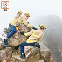 消防員登上山頂搜索墮崖男子。