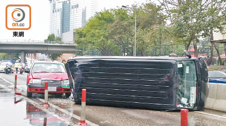 客貨車翻側壓毀的士車頭。（趙瑞麟攝）