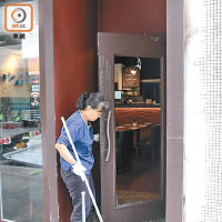 遇竊餐廳工人清理玻璃門碎片。（馬竟峯攝）