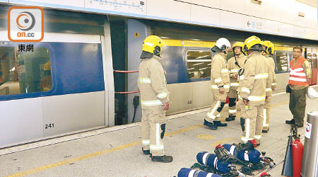 港鐵列車冒煙，消防員在月台旁戒備。（林耀康攝）