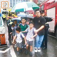 半山<br> 半山發生校巴車禍，學童由警員帶領冒雨離開現場。（馬竟峯攝）