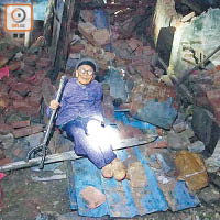 事主劉先生的外祖母坐在廢墟中哭喊。