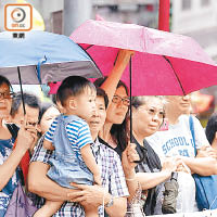 雖然巡遊期間天降微雨，市民仍夾道觀賞表演。