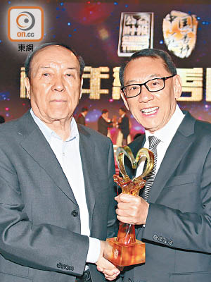 楊受成（右）獲司馬義‧艾買提頒授「中國慈善榜年度十大慈善家」獎座。（受訪者提供圖片）