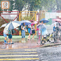 大批學童昨早冒着滂沱大雨返學，甫出門已一身狼狽。