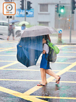 大雨中返學，最怕衫褲鞋襪盡濕。 （王偉安攝）