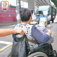 有市民將香橙塞滿環保袋，放在坐着輪椅的老人膝上推走。