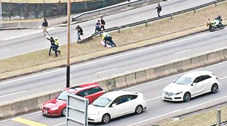 東隧伏兵 圖攔車隊<br>多名香港眾志成員衝出東隧出口馬路，企圖攔截張德江車隊示威。（香港眾志fb圖片）