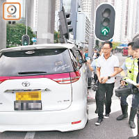 涉醉駕司機在車旁協助警員調查。