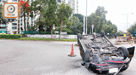 私家車掃毀路旁鐵欄後翻轉。（賴南秋攝）