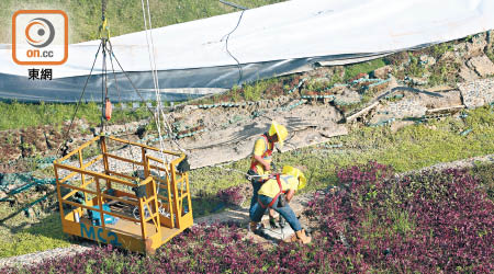 兩名工人在倒塌綠化天台鑽地。（黃偉邦攝）