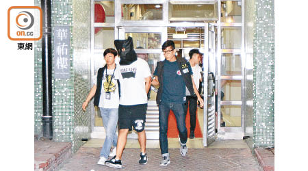 其中一名疑犯被押往天華邨單位搜查。（文健雄攝）