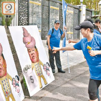 正義聯盟成員向頭頂滿布糞便嘅漢奸黎肖像紙板掟飛鏢，聲言「釘死」佢。