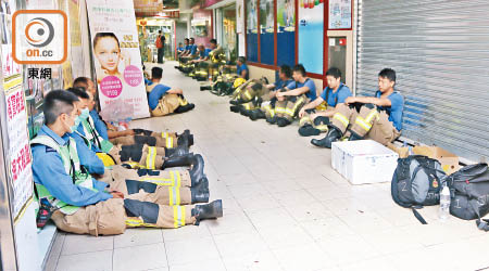 消防員通宵撲救，累極坐在商場地下休息。